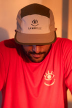 Casquette 5 volets vert army et beige, logo brodé La Marelle Comedy Club Bordeaux t-shirt rouge logo oeil qui sourit coeur